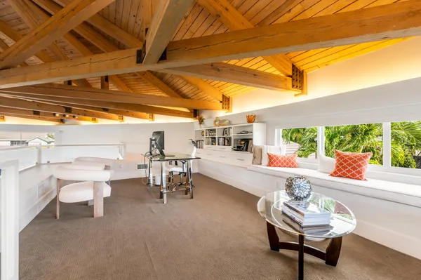 a living room with patio furniture and a grill