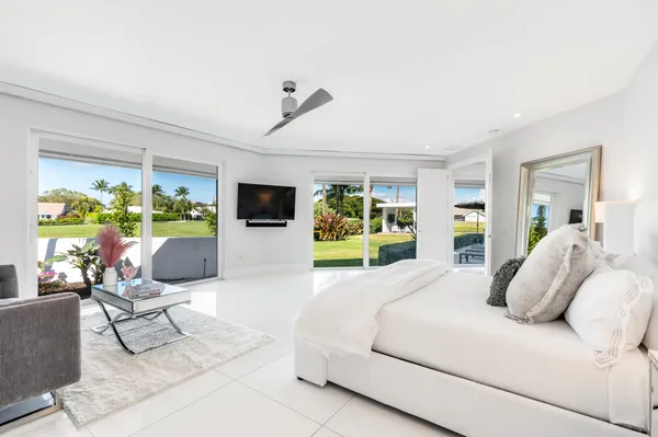 a bedroom with a bed a flat screen tv and a large window