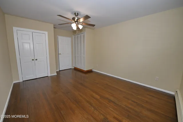 a view of an empty room with wooden floor