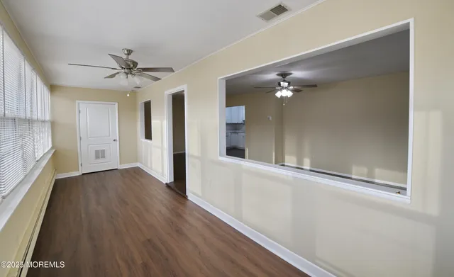 a view of a hallway with wooden floor and a chandelier