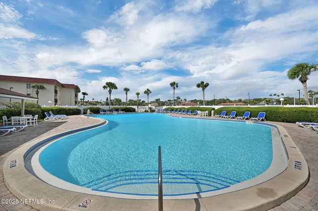 a bed sitting in a bedroom next to a window with a book shelf