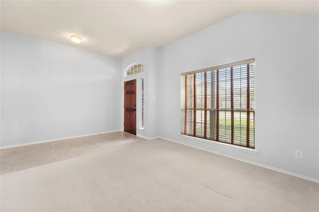 an empty room with ceiling fan and window