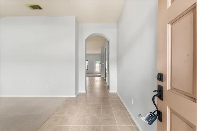 a view of a hallway with wooden floor and a bathroom