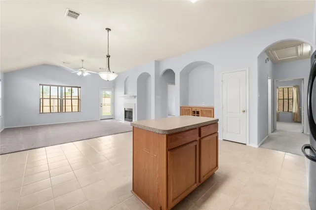 a view of a kitchen with a sink a chandelier and living room view