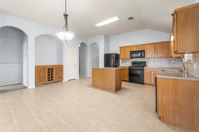 a large kitchen with cabinets and stainless steel appliances