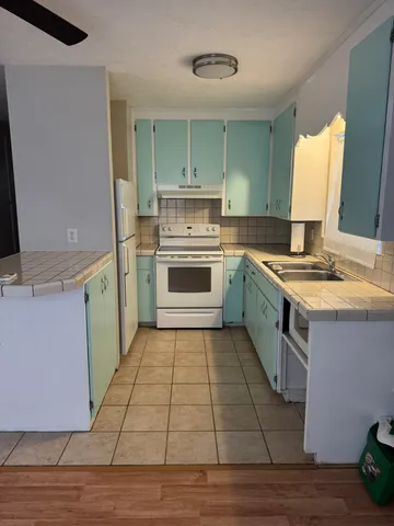 a kitchen with a stove sink and cabinets