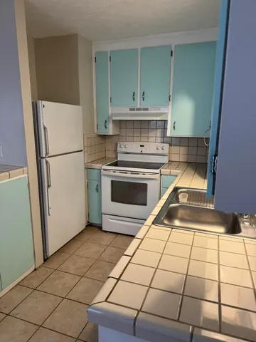 a kitchen with a stove top oven and cabinets