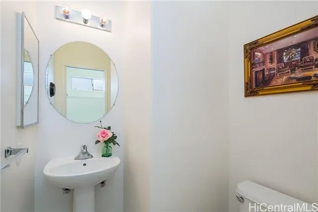 a bathroom with a sink mirror and toilet