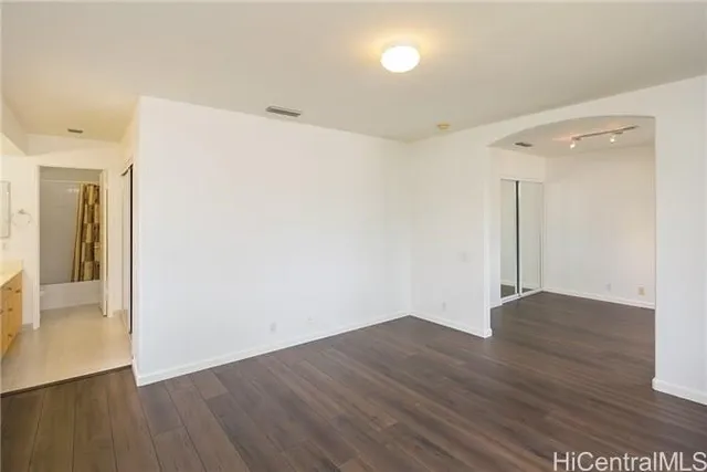 a view of an empty room with wooden floor