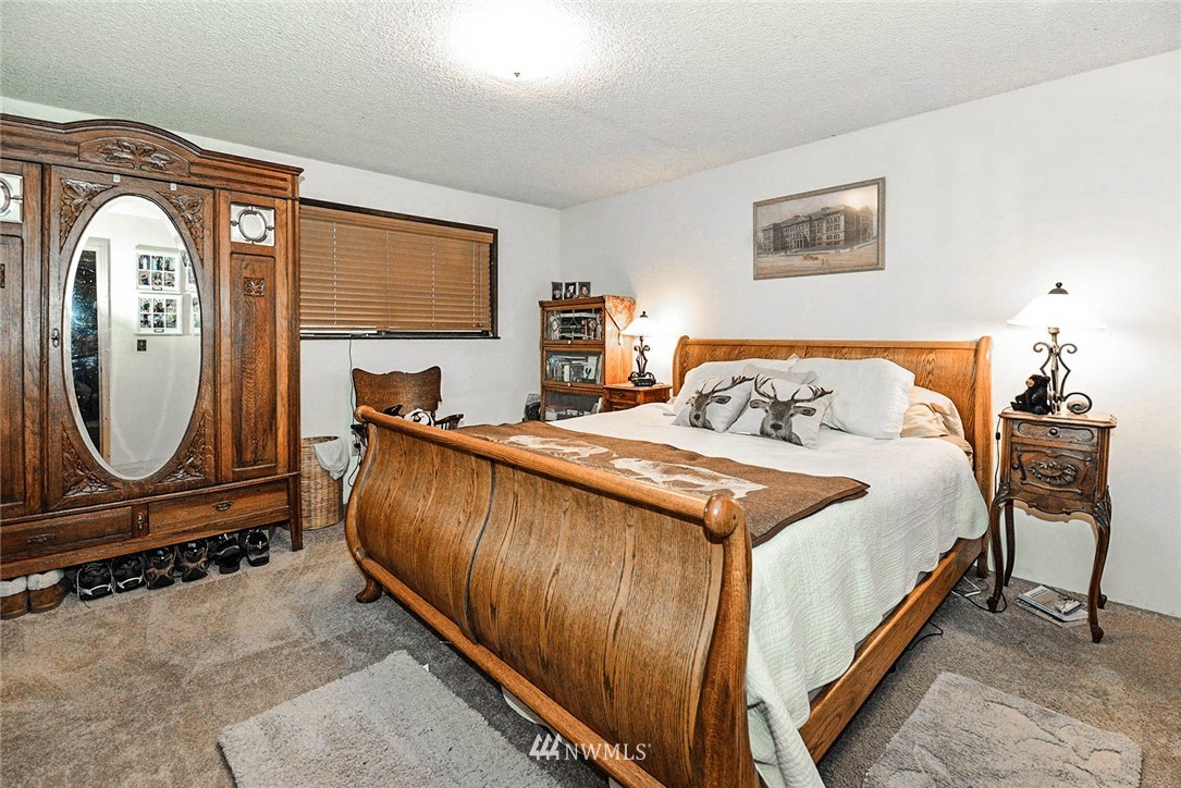 20431 Welch Road Snohomish, WA 98296 - Photo 10 of 25 a bedroom with a bed a mirror and dresser