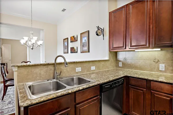 a kitchen with a sink cabinets and chandelier