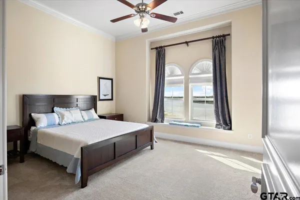 a bedroom with a bed lamp and a large window