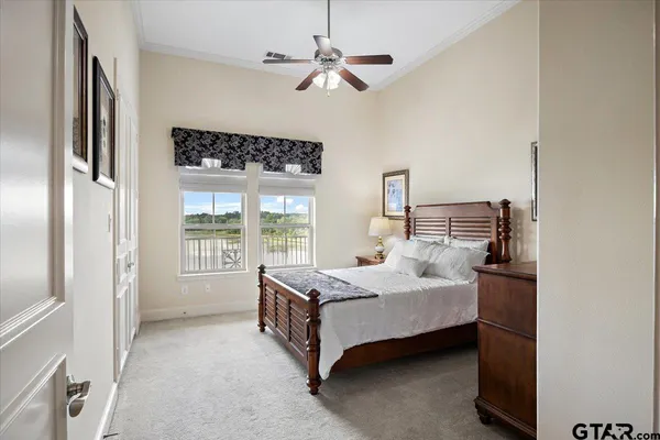 a bedroom with a bed lamp and a large window