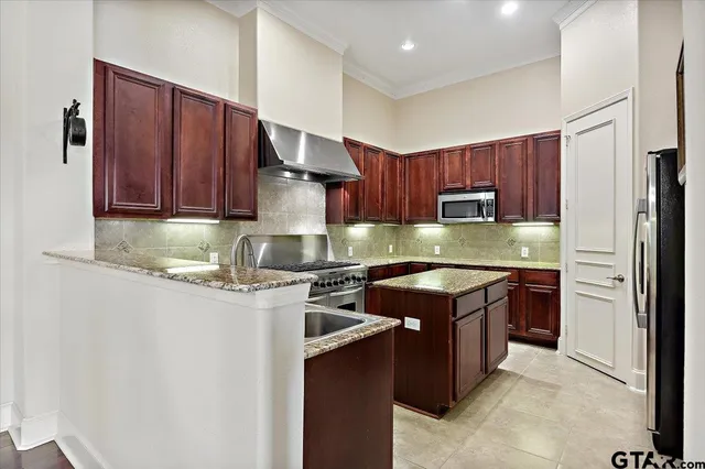 a kitchen with stainless steel appliances granite countertop a stove a sink dishwasher and a refrigerator