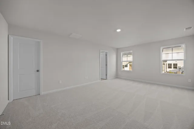 a view of an empty room with a window and fireplace