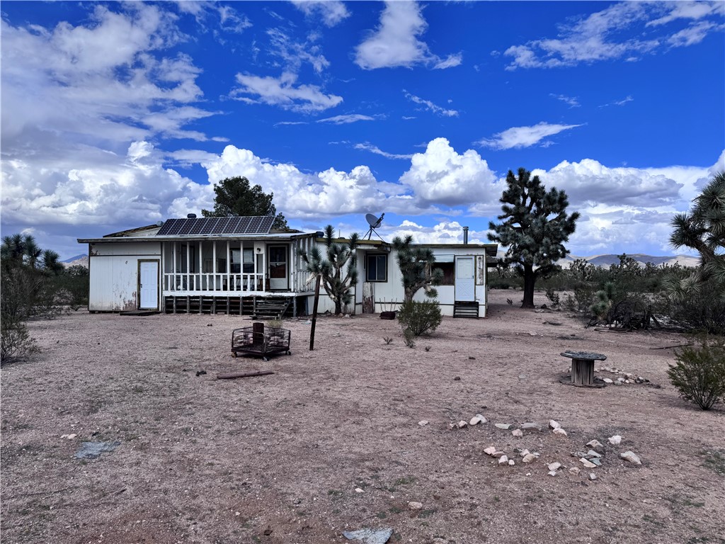 21188 South Cheyenne Road Yucca, AZ 86438 - Photo 5 of 24 View of front of house featuring solar panels and a sunroom