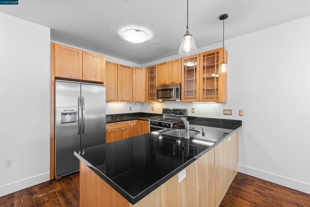 2300 Broadway Oakland, CA 94612 - Photo 7 of 32 a kitchen with granite countertop a sink stainless steel appliances and cabinets