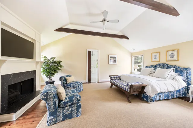 a spacious bedroom with a bed a couch and a flat screen tv