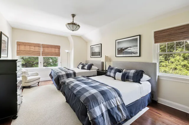 a bedroom with two beds and a large window