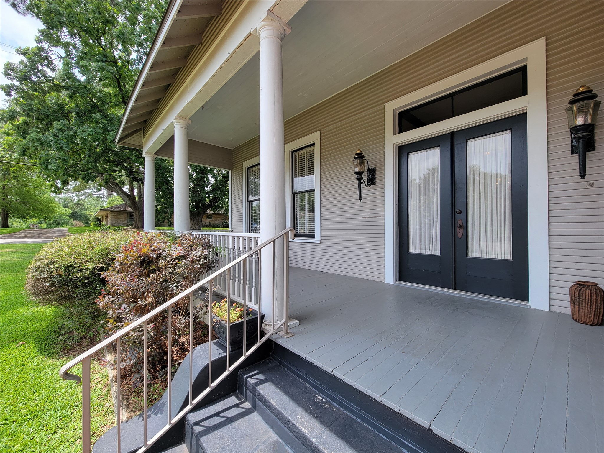 1406 Key Street Brenham, TX 77833 - Photo 4 of 50 Charming large front porch with elegant white columns and welcoming double glass doors featuring transoms.