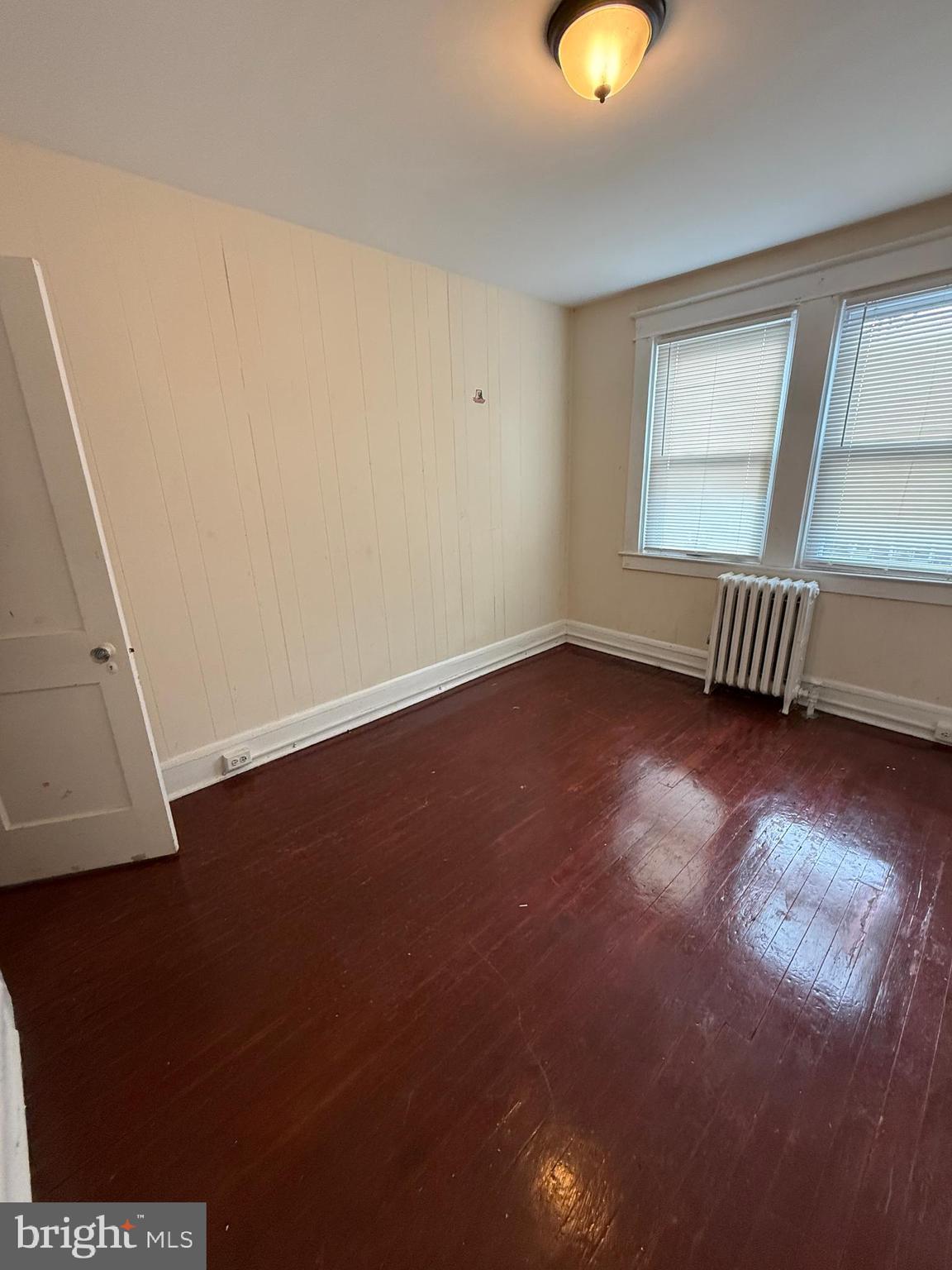 3309 Brighton Street Baltimore, MD 21216 - Photo 11 of 32 an empty room with wooden floor and windows