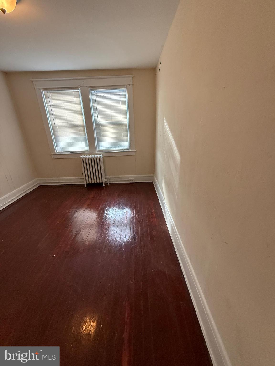3309 Brighton Street Baltimore, MD 21216 - Photo 15 of 32 a view of an empty room with wooden floor and a window