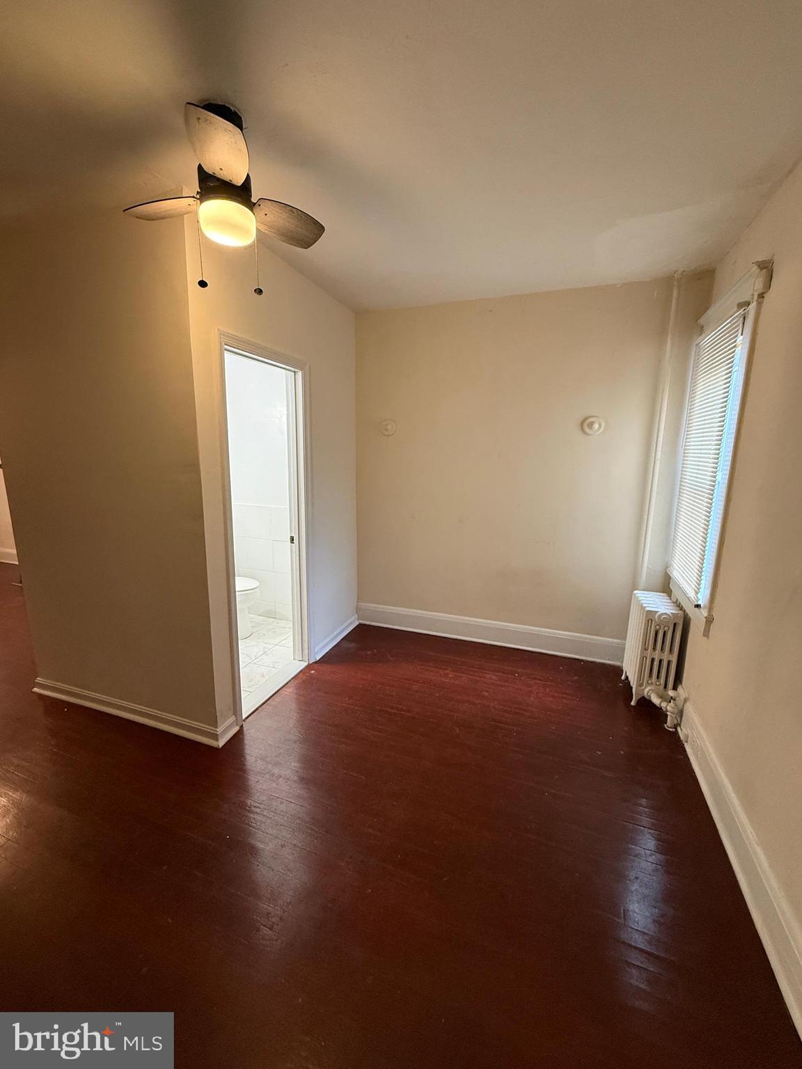 3309 Brighton Street Baltimore, MD 21216 - Photo 27 of 32 an empty room with wooden floor and a window
