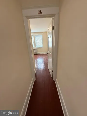 a view of a hallway with wooden floor