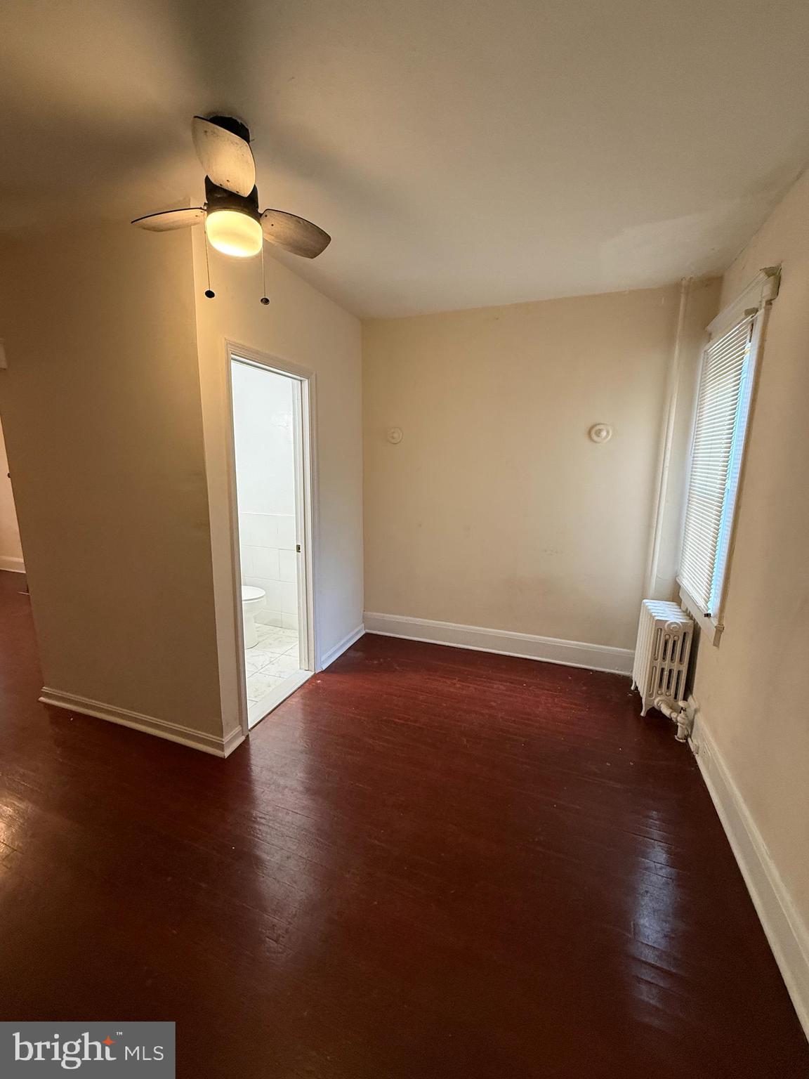 3309 Brighton Street Baltimore, MD 21216 - Photo 6 of 32 an empty room with wooden floor and a window
