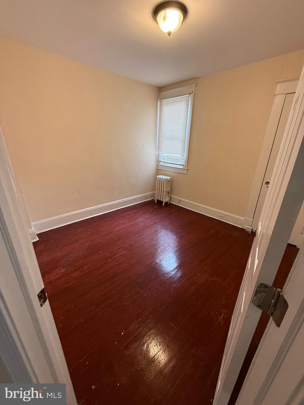 3309 Brighton Street Baltimore, MD 21216 - Photo 9 of 32 an empty room with wooden floor and windows