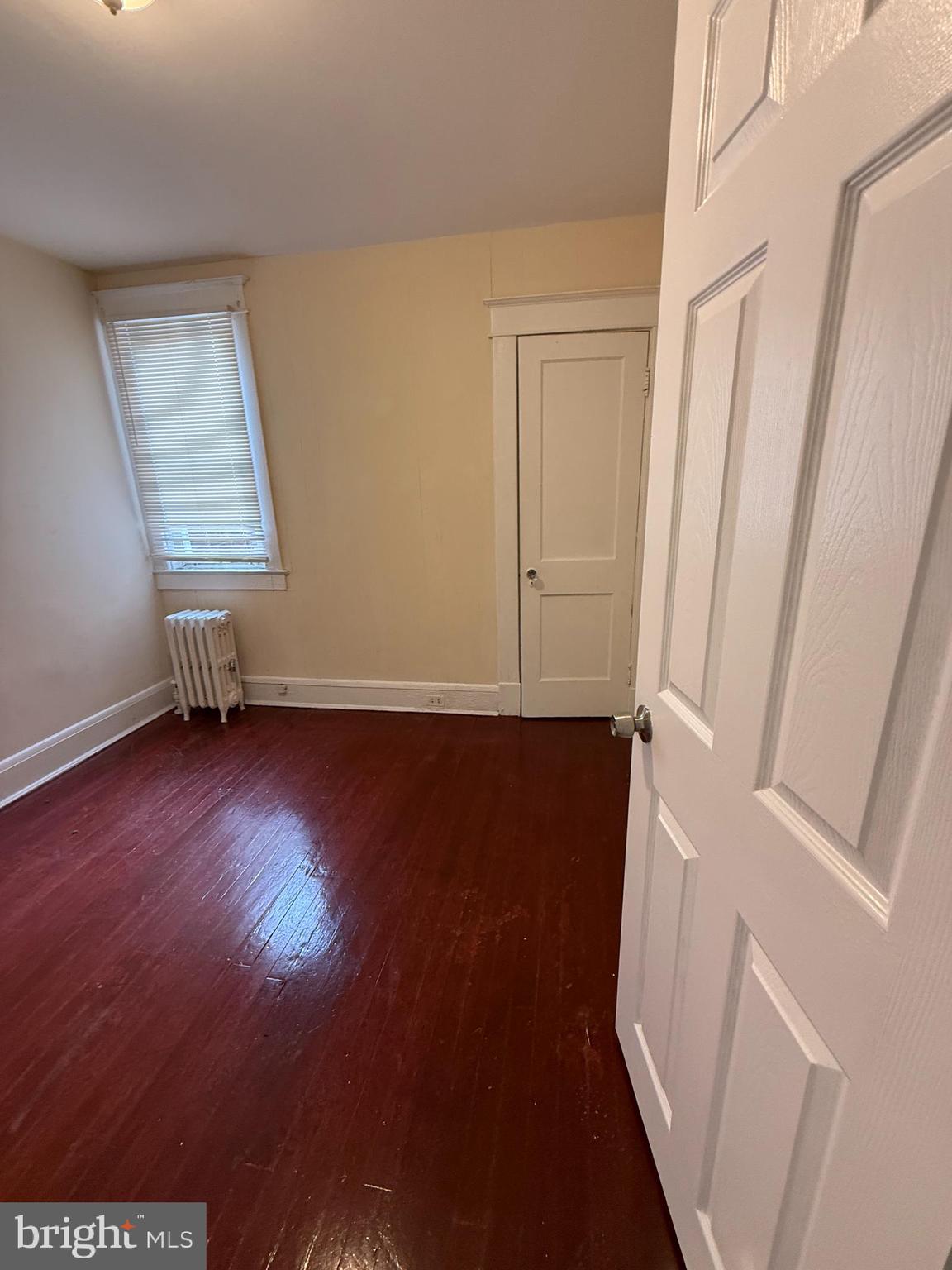 3309 Brighton Street Baltimore, MD 21216 - Photo 10 of 32 an empty room with wooden floor and windows