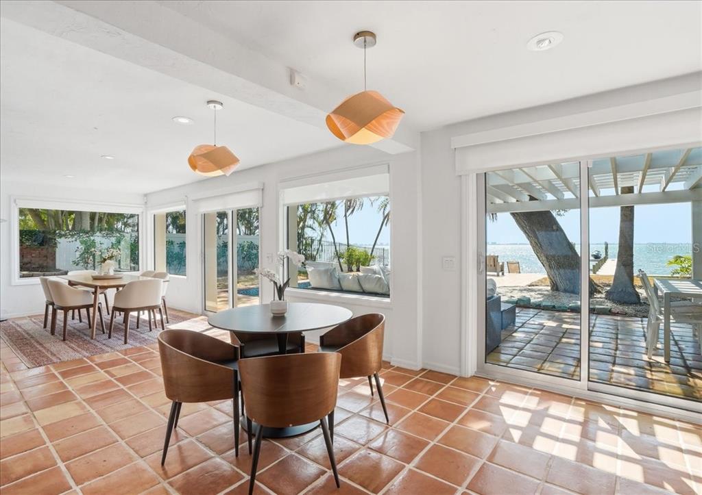 3127 Bay Shore Road Sarasota, FL 34234 - Photo 17 of 78 a dining room with furniture and a floor to ceiling window
