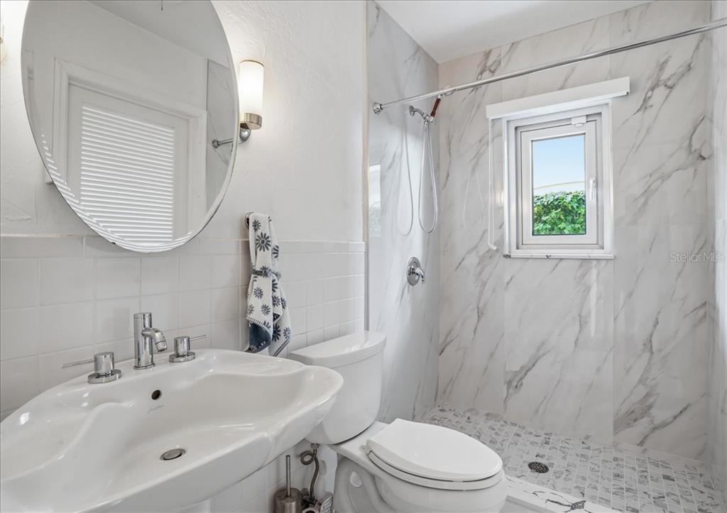 3127 Bay Shore Road Sarasota, FL 34234 - Photo 34 of 78 a bathroom with a sink a toilet and shower