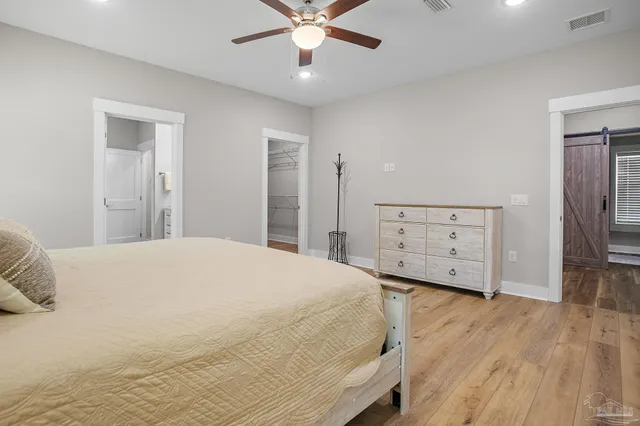 a spacious bedroom with a bed and a dresser