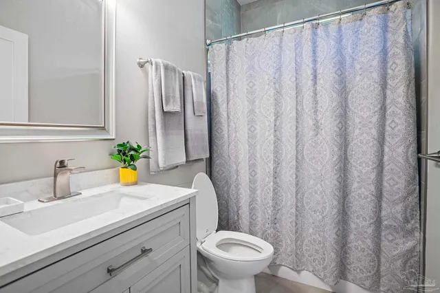 a bathroom with a sink a toilet and shower curtain