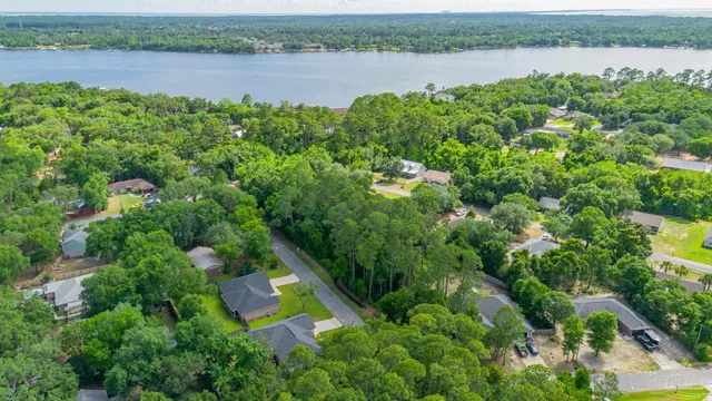 an aerial view of lake with residential house with outdoor space and trees