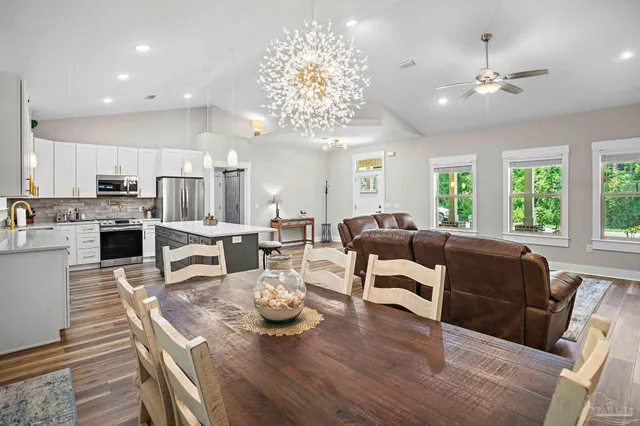 a living room with furniture kitchen and a chandelier
