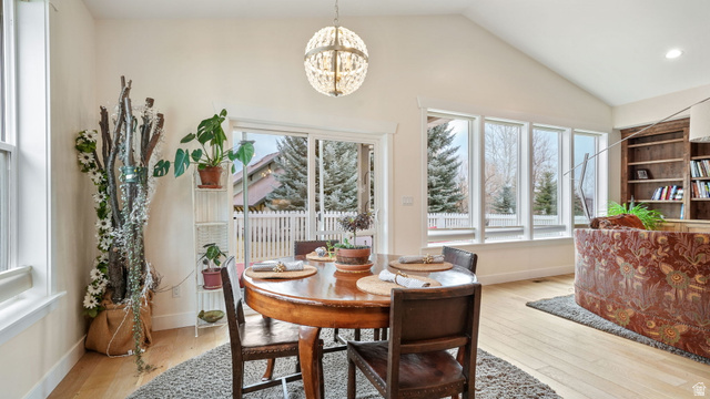 1238 Canyon View Road Midway, UT 84049 - Photo 10 of 36 Vaulted ceiling dining area featuring wood-finish flooring, a contemporary chandelier, and a wall of windows