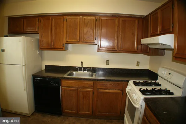 a kitchen with a sink a stove and cabinets