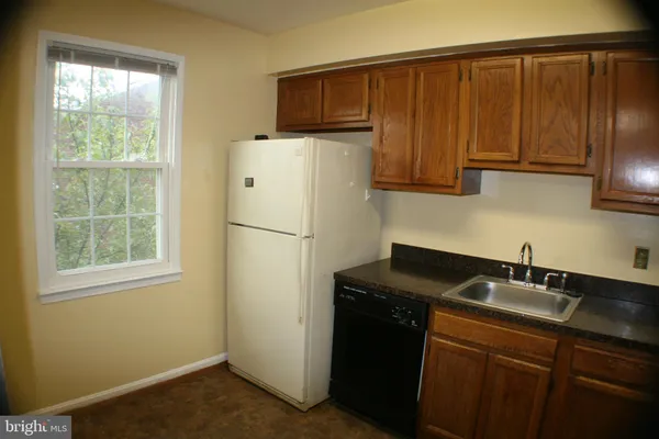 a kitchen with a refrigerator a sink and cabinets