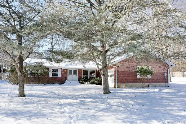 a front view of a house with a yard and potted plants