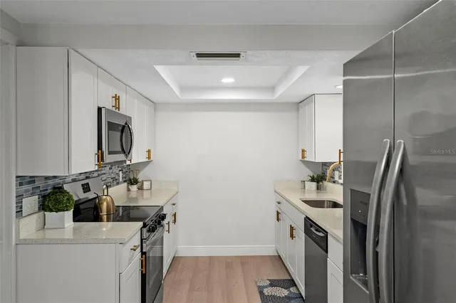 a kitchen that has a sink a stove and a refrigerator