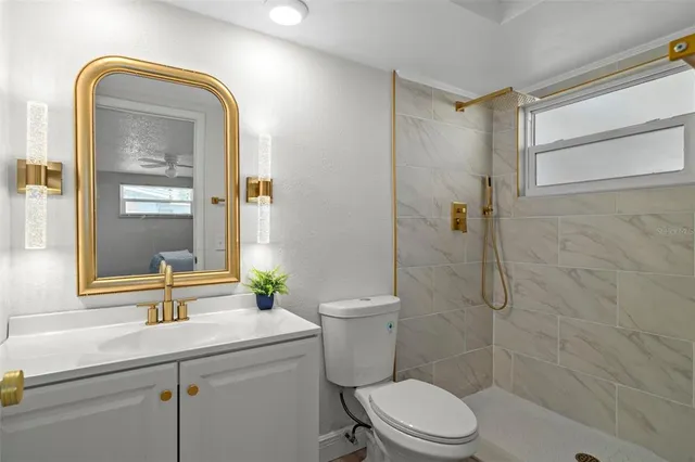 a bathroom with a sink a toilet and shower