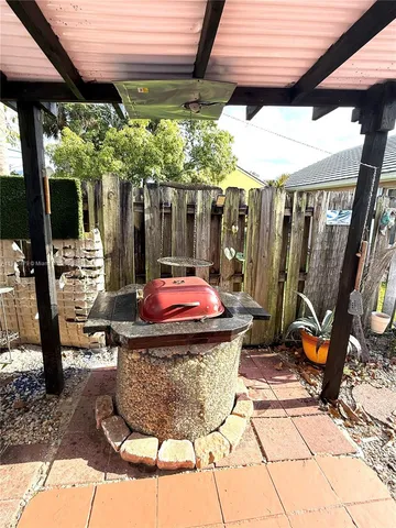 a view of a patio with table and chairs potted plants and floor to ceiling window