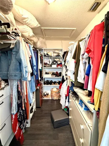 a view of walk in closet with clothes