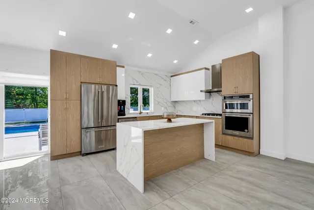 a kitchen with a refrigerator and a stove top oven