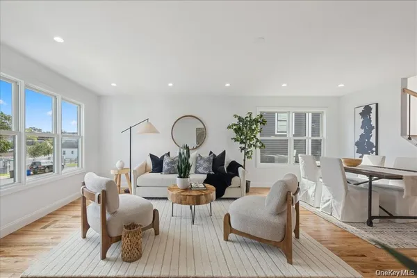 a living room with furniture a large window and wooden floor