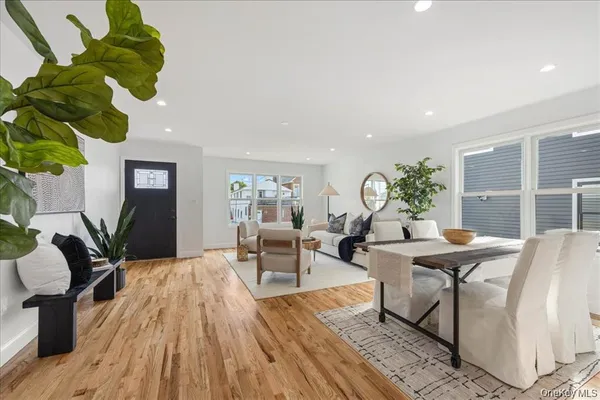 a living room with furniture flowers and wooden floor