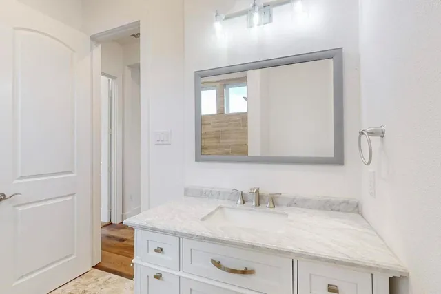 a bathroom with a granite countertop sink and a mirror