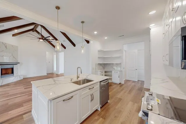 a kitchen with a sink dishwasher a stove and a refrigerator with wooden floor
